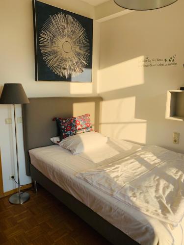 a bedroom with a bed and a lamp and a picture at Gästehaus der Abtei Sayn in Bendorf