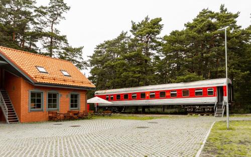 a red and white train parked next to a building at Palanga Camping Hostel in Palanga