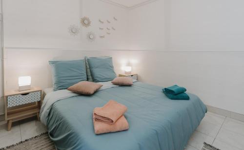 - un grand lit bleu avec deux oreillers dans l'établissement 30 mètres de la plage et des planches. Tout à pied !, à Trouville-sur-Mer