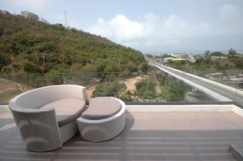 a balcony with two chairs and a view of a road at Manita Boutique Hotel in Pattaya South