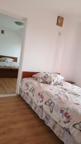 a bedroom with a bed with a comforter on it at La Curtea Argeseana in Valea Iasului