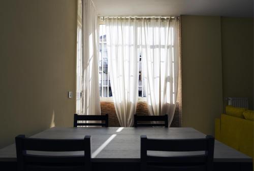 a dining room table with chairs and a large window at STANZA EUCALIPTO in Caserta