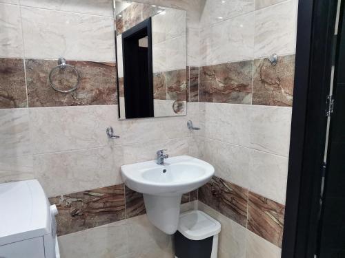 a bathroom with a sink and a toilet and a mirror at Family Apartment for Short-Term Vacation in Primorsko