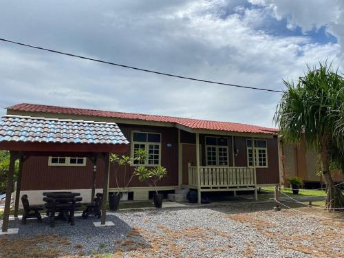 a small house with a porch and a table at Tamteh Homestay in Ayer Hitam