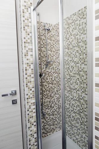 a shower in a bathroom with tiled walls at Stanza Olmo Caserta in Caserta