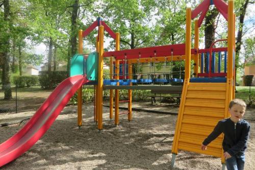 un jeune garçon se tenant devant une aire de jeux dans l'établissement Bonheur, à Monflanquin
