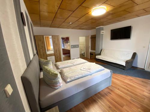 a living room with a couch and a bed in it at Pension Florion in Bernburg