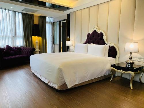 a bedroom with a large white bed and a couch at CHECK inn SELECT Hualien LinSen in Hualien City
