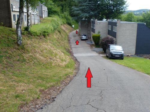 a street with two red arrows on the road at Les terrasses de Malmedy Studio 333 Yellow Grey in Malmedy