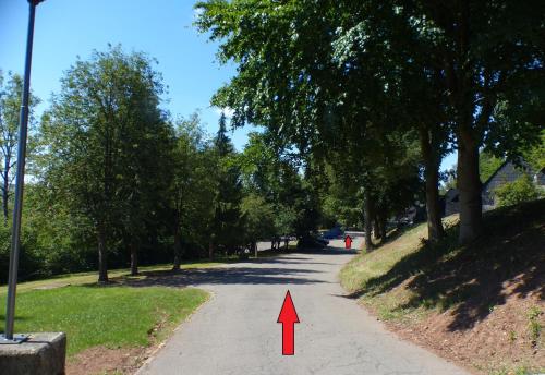 a red arrow is pointing down a road at Les terrasses de Malmedy Studio 333 Yellow Grey in Malmedy