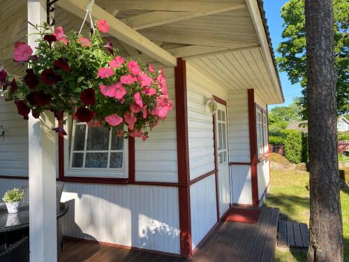 a porch of a house with a window and flowers at Sinisalu Apartments in Käsmu