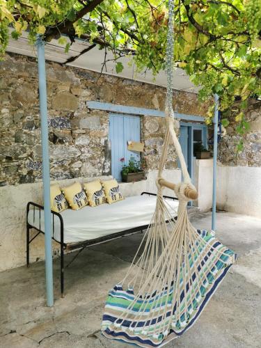 a hammock in front of a stone building at Holiday House Prodromos in Prodromos