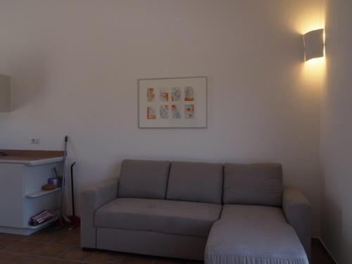a living room with a couch and a picture on the wall at Stazzu Giasti Agriturismo in Aglientu