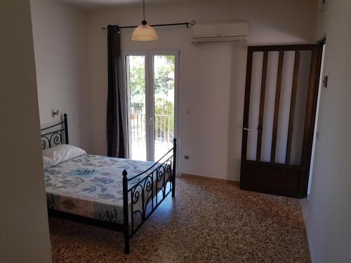 una camera con letto e porta scorrevole in vetro di Filippos Apartments "Apartment 1" a Cefalonia