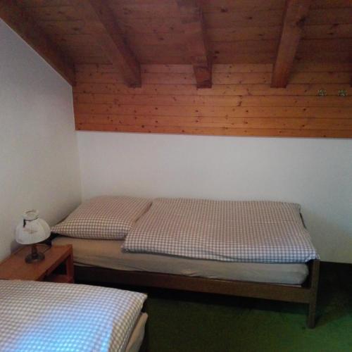 a bedroom with two beds and a wooden wall at Chalet-Schümli Maisonette in Ernen