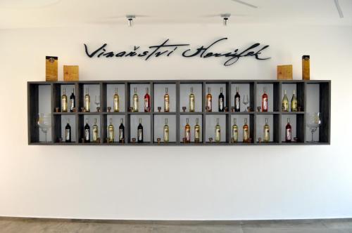 a shelf of wine bottles on a wall at Vinařství Herůfek in Zaječí