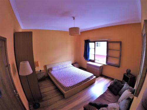 1 dormitorio con cama, sofá y ventana en A Casa Mia en Las Palmas de Gran Canaria