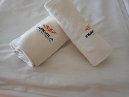 two rolled up towels sitting on a bed at Pergola Panzió in Balatonföldvár
