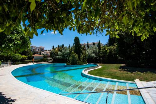 una piscina en medio de un jardín en Cozy Apartment in Paphos Beautiful Complex, en Pafos