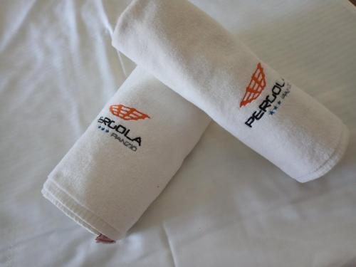 a roll of toilet paper sitting on a bed at Pergola Panzió in Balatonföldvár
