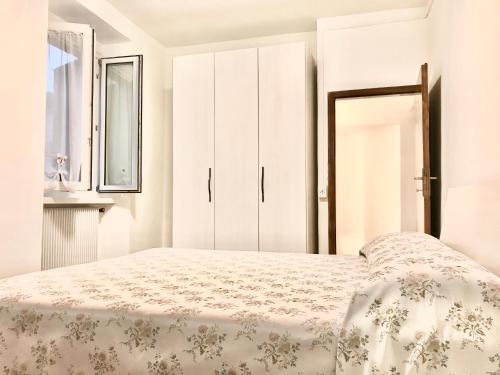 a white bedroom with a bed and a window at La finestra sul Brenta in Lasino