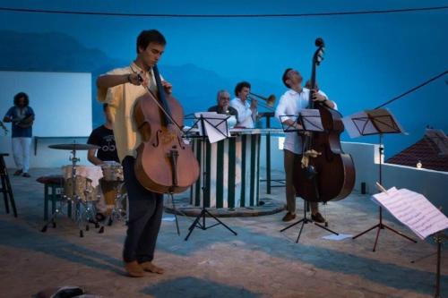 a man playing a cello in front of a group of musicians at Hostel Dalmatia in Marusici 
