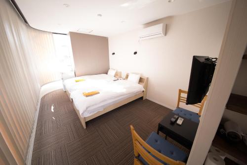 洲本市にあるシティー 海月のベッド1台とテレビが備わる小さな客室です。