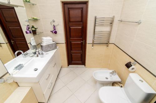a white bathroom with a sink and a toilet at ERA RENT Apartments in Chişinău