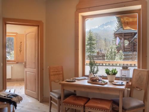 a dining room with a table and a large window at Willa Mirwa in Zakopane
