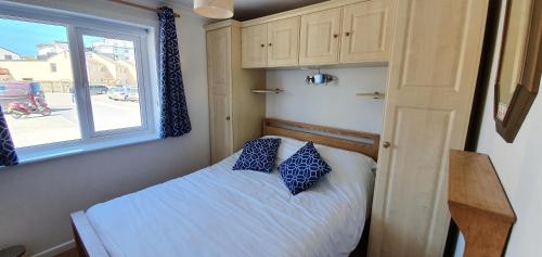 niewielka sypialnia z łóżkiem i oknem w obiekcie 7 Penhale w mieście Perranporth