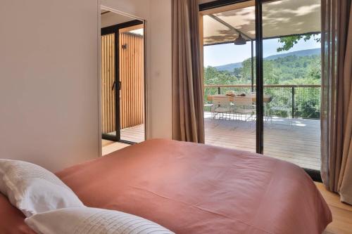 - une chambre avec un lit et une vue sur une terrasse dans l'établissement Les Cabanes de la Fontaine, à Lacoste