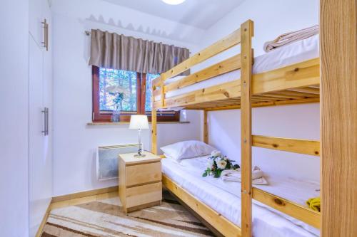a bedroom with two bunk beds and a lamp at Topaz Apartamenty Mozaika Centrum dwie sypialnie in Zakopane