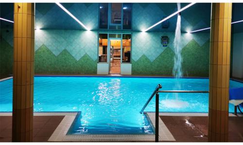 - une piscine avec une fontaine en soirée dans l'établissement Wyspa Mszanka, à Mszana Dolna