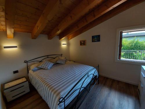 una camera con un letto in una stanza con una finestra di B&B Stella Alpina a Fontanelle