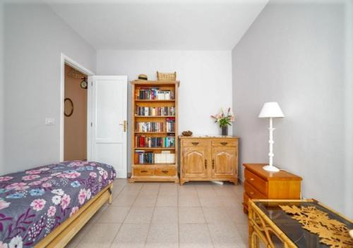 a bedroom with a bed and a book shelf with books at Apartamento Sol y Mar in Tazacorte