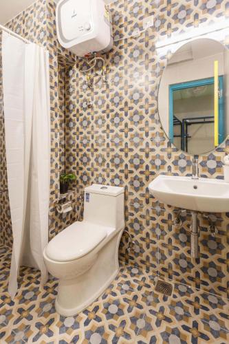 a bathroom with a toilet and a sink and a mirror at Locul Central - Church Street in Bengaluru