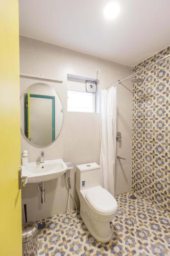 a bathroom with a toilet and a sink and a mirror at Locul Central - Church Street in Bengaluru