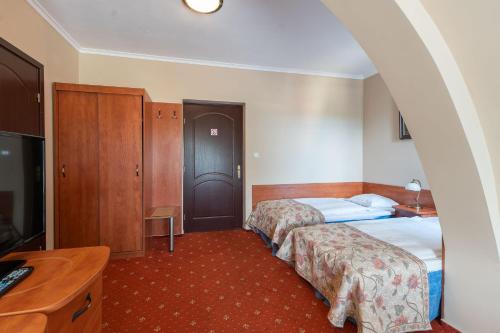 a hotel room with two beds and a desk at Marina in Międzyzdroje