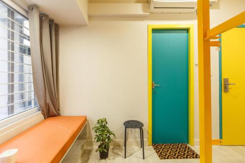 a room with a green door and a stool at Locul Central - Church Street in Bengaluru