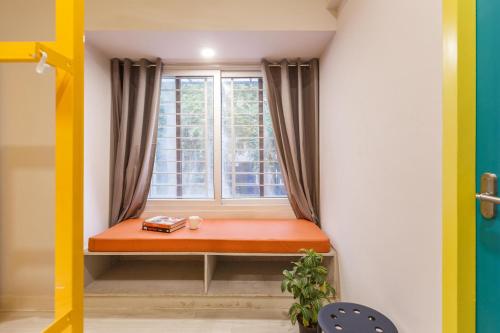a window seat in the corner of a room at Locul Central - Church Street in Bengaluru