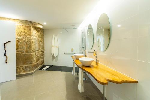 a bathroom with two sinks and a stone wall at GOLDNATURE in Gondomar