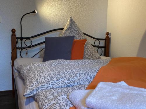 a bed with orange and blue pillows on it at Hotelik Gdanska in Oberhausen