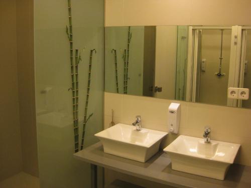 bagno con 2 lavandini e specchio di albergue SANTO SANTIAGO a Santiago de Compostela
