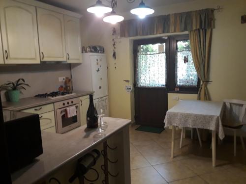 une cuisine avec des placards blancs, une table et une fenêtre dans l'établissement Casa VIP, à Bacău