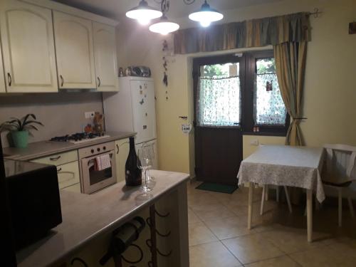a kitchen with white cabinets and a table and a window at Casa VIP in Bacău