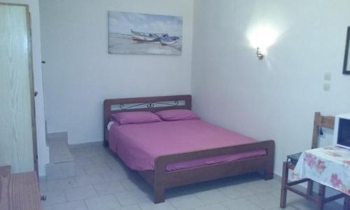 a bedroom with a bed with a purple blanket at Kitesurf Paradise Studios in Theologos