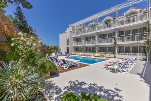 a hotel with a swimming pool and lounge chairs at Hotel Osejava in Makarska