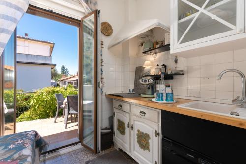 una cucina con lavandino e porta scorrevole in vetro di Muggia Uphill B&B a Múggia