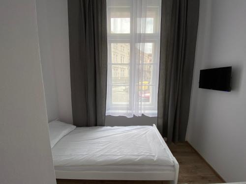 Cama pequeña en habitación con ventana en Apartamenty Stare Miasto, en Bydgoszcz