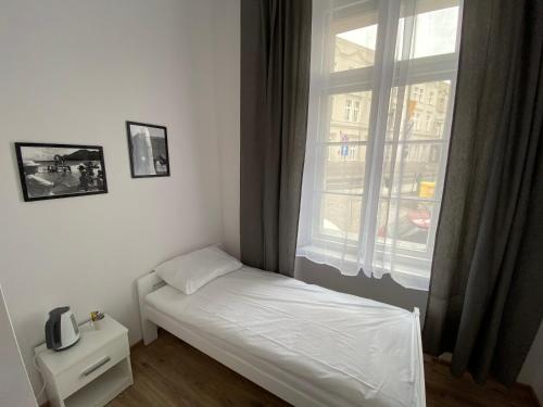 Cama pequeña en habitación con ventana en Apartamenty Stare Miasto, en Bydgoszcz